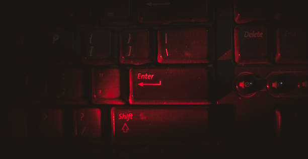 istock Red light is highlighting on keyboard's enter button in dark . 1276950758