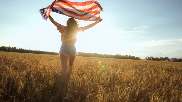 istock Young woman waves an american flag 1276951227