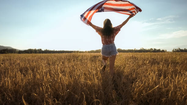 istock Young woman waves an american flag 1276951322