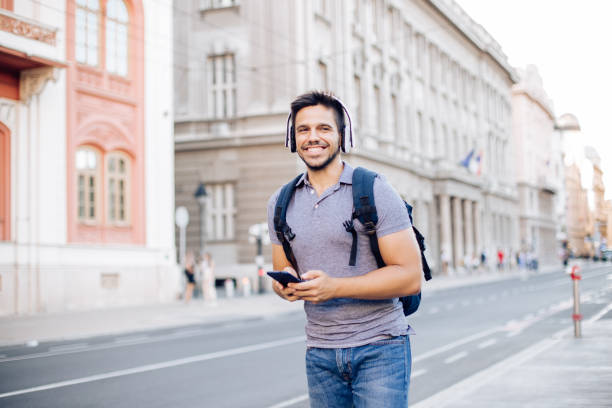 istock Happy student using phone on his way to the university 1276952181