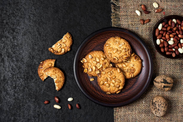 istock Homemade peanut cookies on a brown plate with raw peanuts in background 1276959332