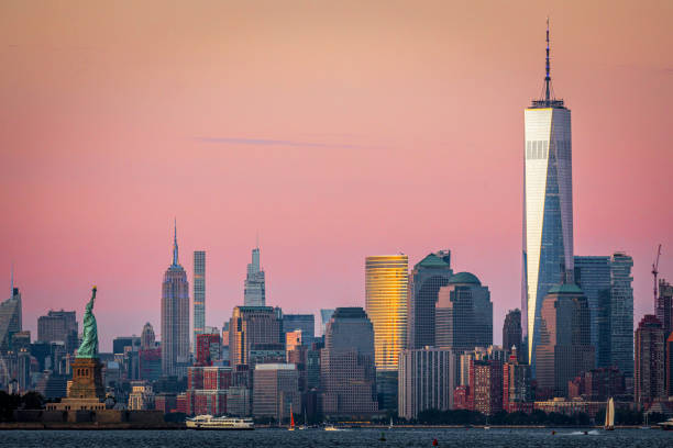 Sunset in Lower Manhattan Colorful sunset shot of Lower Manhattan with the Freedom Tower in the foreground and the Empire State Building in the distance. to the struggle against world terrorism statue photos stock pictures, royalty-free photos & images