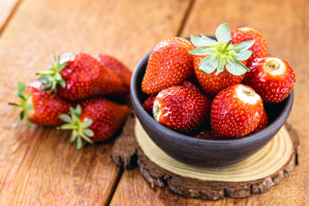 istock fresh strawberries on rustic wooden background, in handmade clay bowl, space for text 1276960821