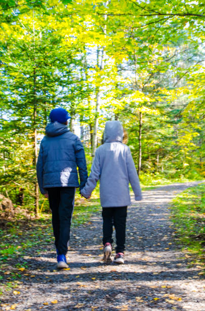istock Two kids walking in forest path during day of autumn 1276961140