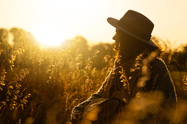 istock Portrait of a woman wearing a hat, with a backpack at sunset. 1276963708