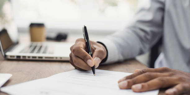 documento de firma de hombre de negocios, mano sosteniendo bolígrafo poniendo firma en papel - llenar el formulario fotografías e imágenes de stock