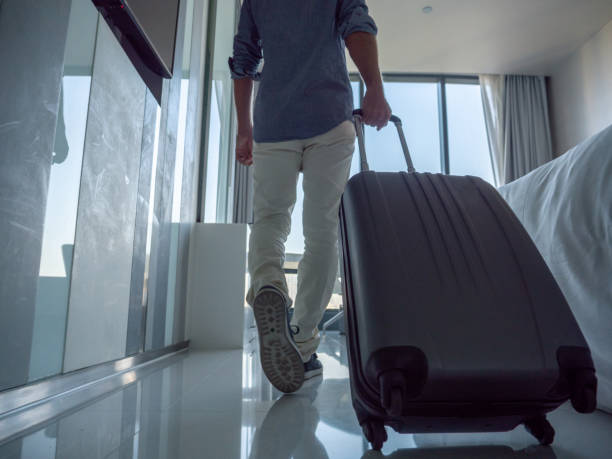 istock Man entering hotel room with carry-on luggage 1276966908