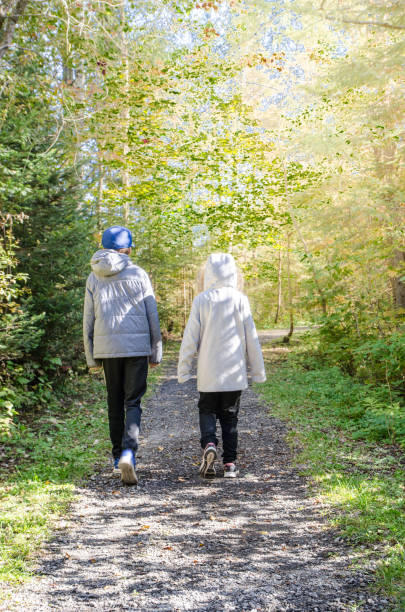 istock Two kids walking in forest path during day of autumn 1276968826