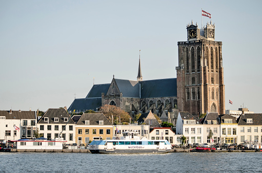Dordrecht, The Netherlands, September 19, 2020: the Grote Kerk (Grand Church) towering above the houses on the waterfront of the river Oude Maas