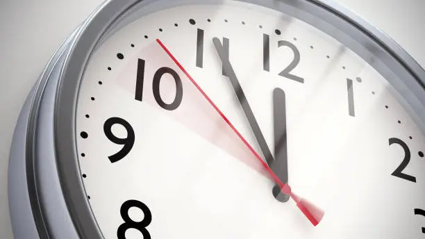 Photo of Metal office clock on white wall closeup