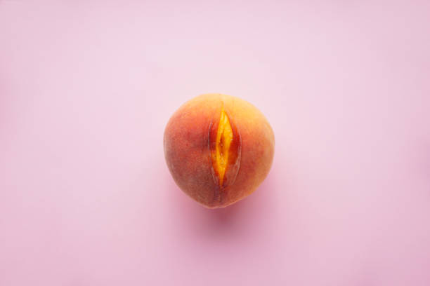 Flat lay composition with juicy peach on a pink background. Sex concept stock photo