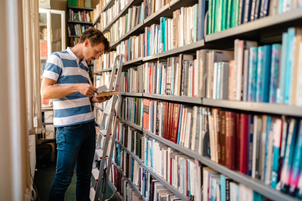 istock Male University student looking for a textbook at University library 1276977056