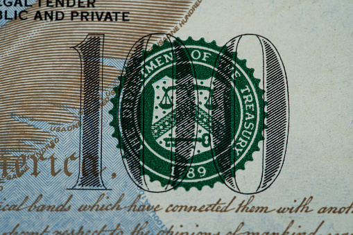 Closeup of number 100 on dollar banknote