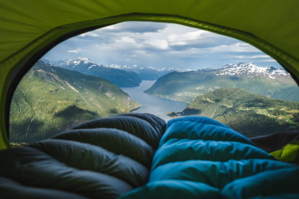 Norwegian fjord viewed from tent. Sleeping bags inside tent in front of fjord in Sunnmore, Norway. tent photos stock pictures, royalty-free photos & images