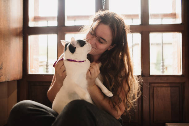 istock Young woman and her cat at home 1276985856