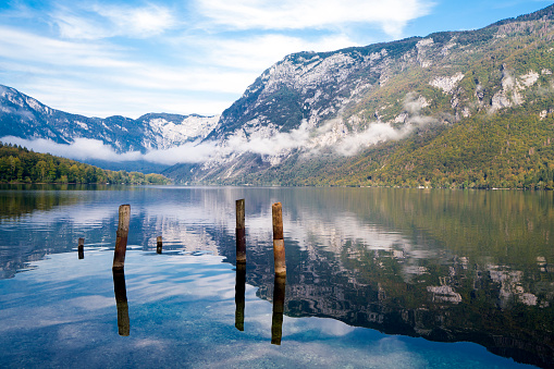 Morning view of Lake Bohinj with clouds and fog reflection in lake water. It is in Julian Alps, Slovenia and is discovered by Slovenia tourists because the coronavirus travel restrictions.  It is starting point to many hiking tours.