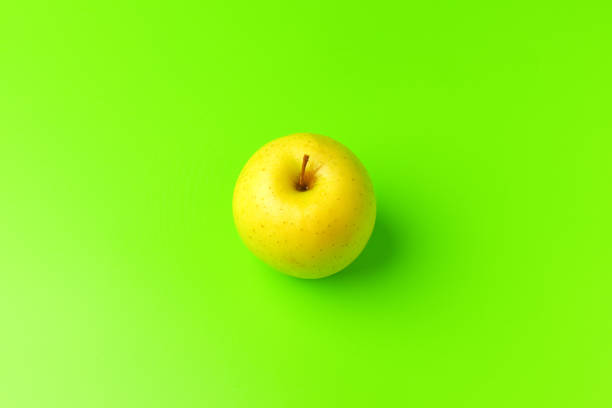 yellow Apple on a green background close-up.isolate