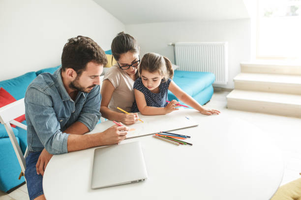 istock Father and mother teach daughter to draw. 1276991454
