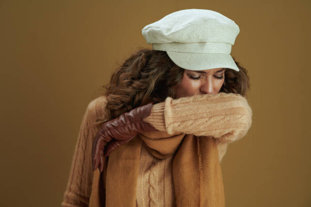 istock modern woman sneezing into elbow against beige background 1276995604