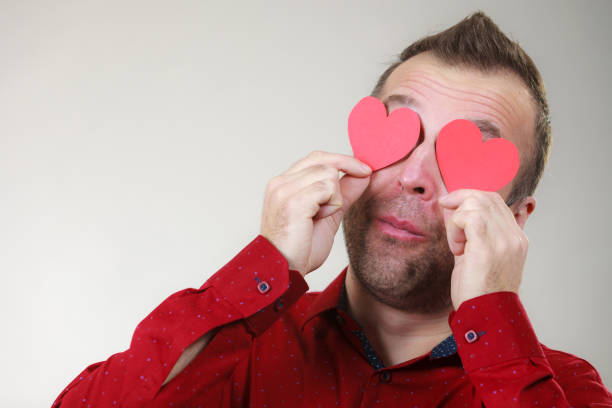 istock Man in love with hearts on eyes 1276995620