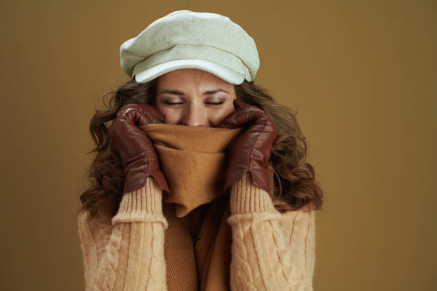 istock smiling elegant woman wrapping in scarf on brown background 1276998917