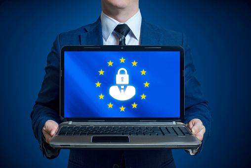 General Data Protection Regulation. A man holds in his hands a laptop with a blue background and a GDPR sign on the screen. GDPR concept