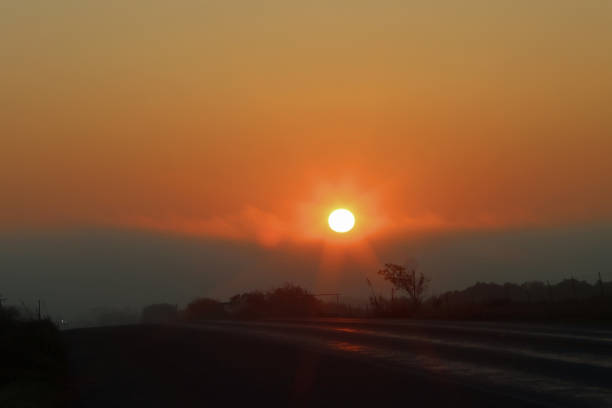 istock Sunrise through the fog with vibrant oranges and red 1277000606