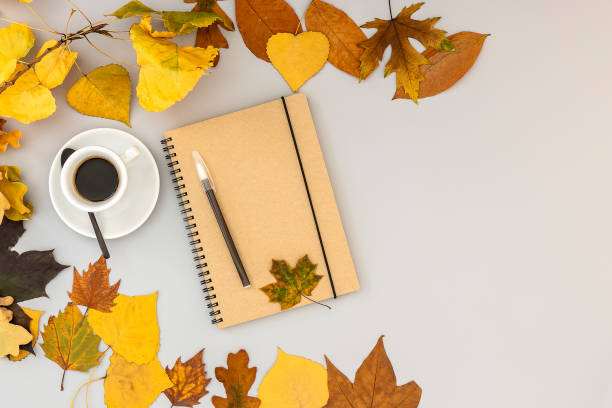 istock Workspace with notebook, pen, autumn leaves, and coffee cup. 1277004713
