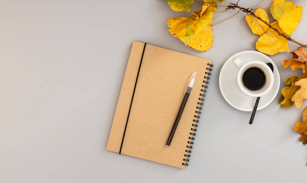 istock Workspace with notebook, pen, autumn leaves, and coffee cup. 1277004720
