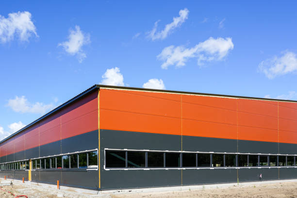 new metal frame factory building, covered with sandwich panels against a blue sky brand new metal frame factory building, covered with sandwich panels against a blue sky sandwich panel photos stock pictures, royalty-free photos & images