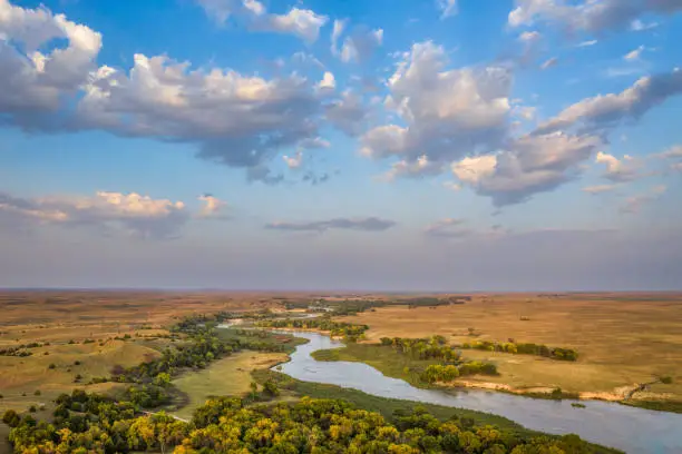 shallow and wide Dismal River flowing through Nebraska Sandhills at Nebraska National Forest, aerial view of afternoon scenery in early fall