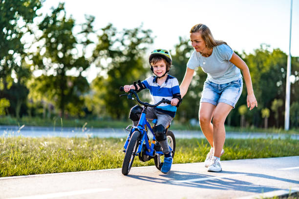 istock Boy learning to ride a bicycle with mother's help 1277010460