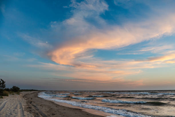 istock Sunset epic clouds on blue sky, waves on sea shore 1277012062