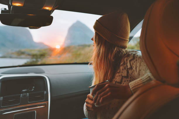 femme sur le voyage de route voyageant par la voiture de location se détendre avec des vacances de style de vie d’aventure de tasse de café vibes extérieur coucher de soleil norvège montagnes vue dans la fenêtre - nature travel locations photos et images de collection