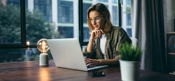 Young woman working with a laptop. Female freelancer connecting to internet via computer. Businesswoman at work