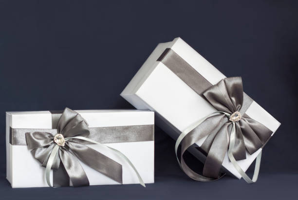 istock The gift box is white with a beautiful gray bow. Gift on a dark background. 1277015799