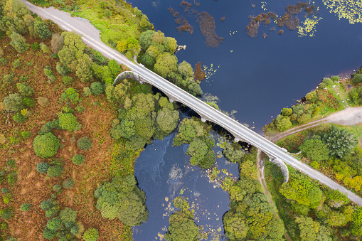 The view from a drone of a disused railway viaduct as it crosses a narrow stretched of water. \nThe location is in Dumfries and Galloway south west Scotland