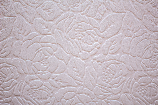 Floral pattern in relief on white paper or fabric.