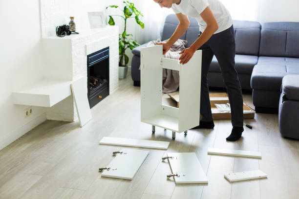young man putting self assembly furniture as they move into your new house. young man putting self assembly furniture as they move into your new house. disassembling stock pictures, royalty-free photos & images