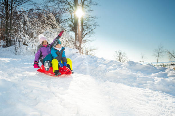 istock Happy children are sledding down the hill 1277019957
