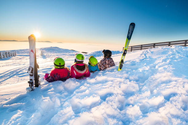 familie liegt auf dem schnee - women group of people lying down mother stock-fotos und bilder