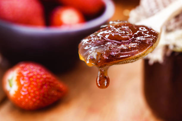 istock wooden spoon with handmade strawberry jam dripping a drop, copy space 1277021166
