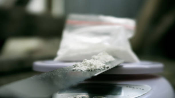 Measuring Cocaine powder on digital scales stock photo