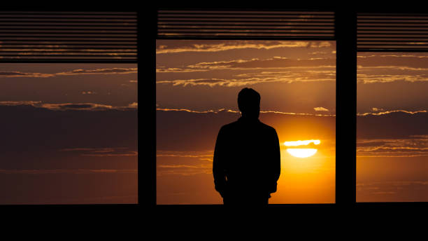 istock The man standing near the window on the sunset background 1277022443