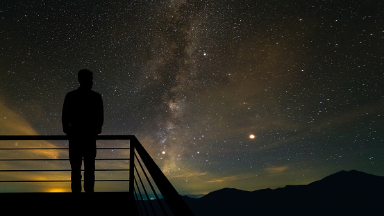 The man standing on the balcony on the starry sky background