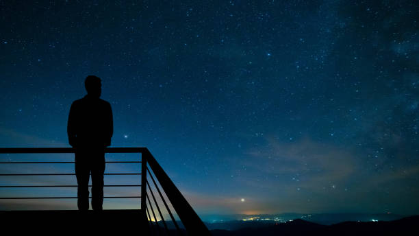 istock The man standing on the balcony on the starry sky background 1277022510