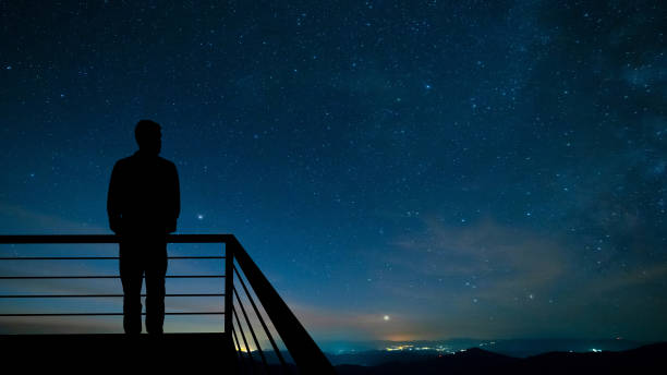 The man standing on the balcony on the starry sky background The man standing on the balcony on the starry sky background meteorite photos stock pictures, royalty-free photos & images