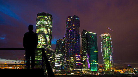 The man standing on the balcony on the night city background