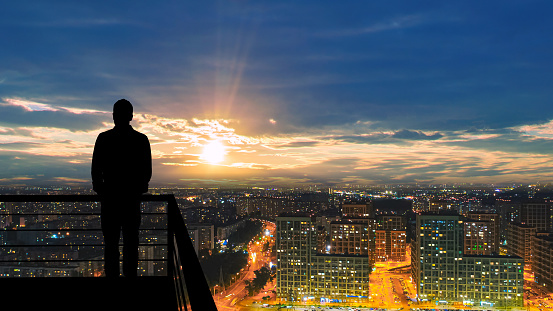 The man standing on the balcony on the big city background