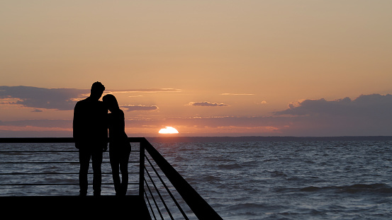 The romantic couple standing on the balcony on the beautiful seascape background